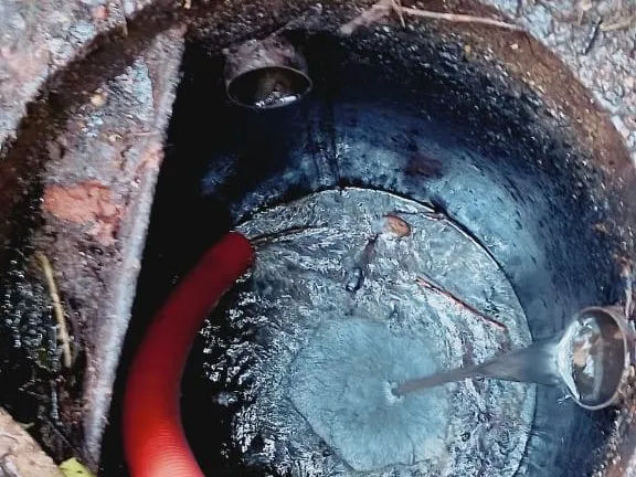 Mangueira de sucção dentro de uma fossa durante a limpeza feita pela FR Renovar